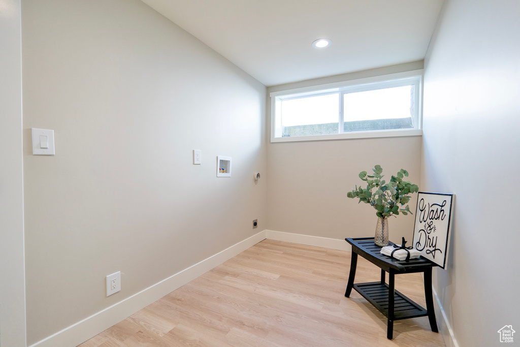 Laundry room with washer hookup, hookup for an electric dryer, light wood-type flooring, laundry area, and baseboards