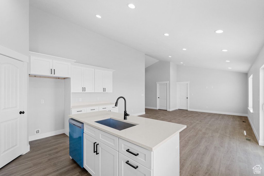 Kitchen with sink, white cabinetry, stainless steel dishwasher, and a center island with sink