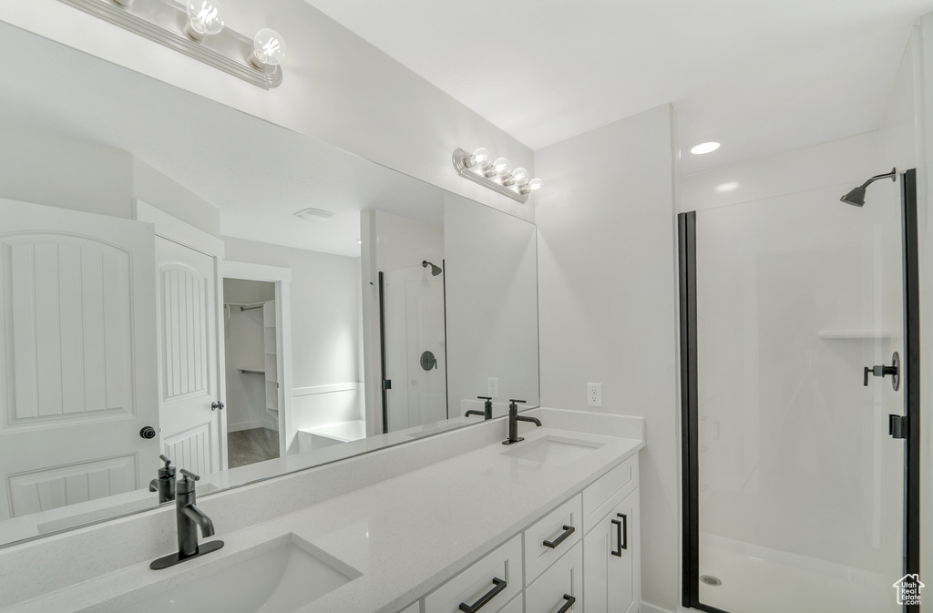 Bathroom featuring double vanity, a sink, and a shower stall