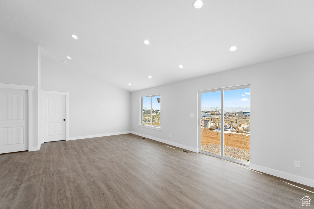Spare room with high vaulted ceiling, wood-type flooring, and a wealth of natural light