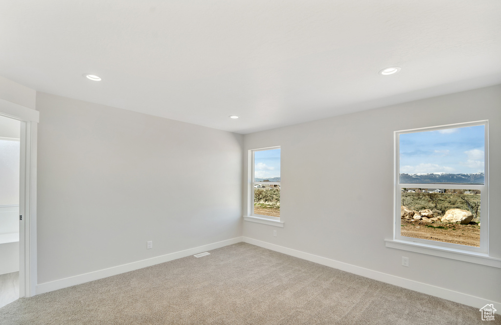Unfurnished room with light carpet, baseboards, and recessed lighting
