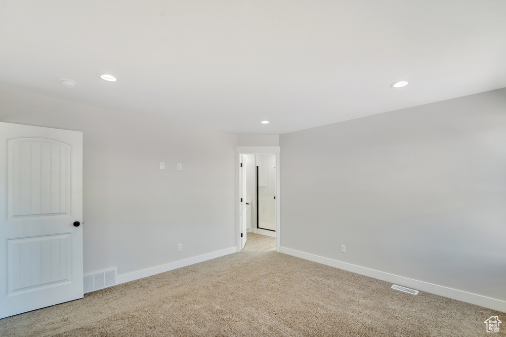 Spare room with recessed lighting, light carpet, baseboards, and visible vents