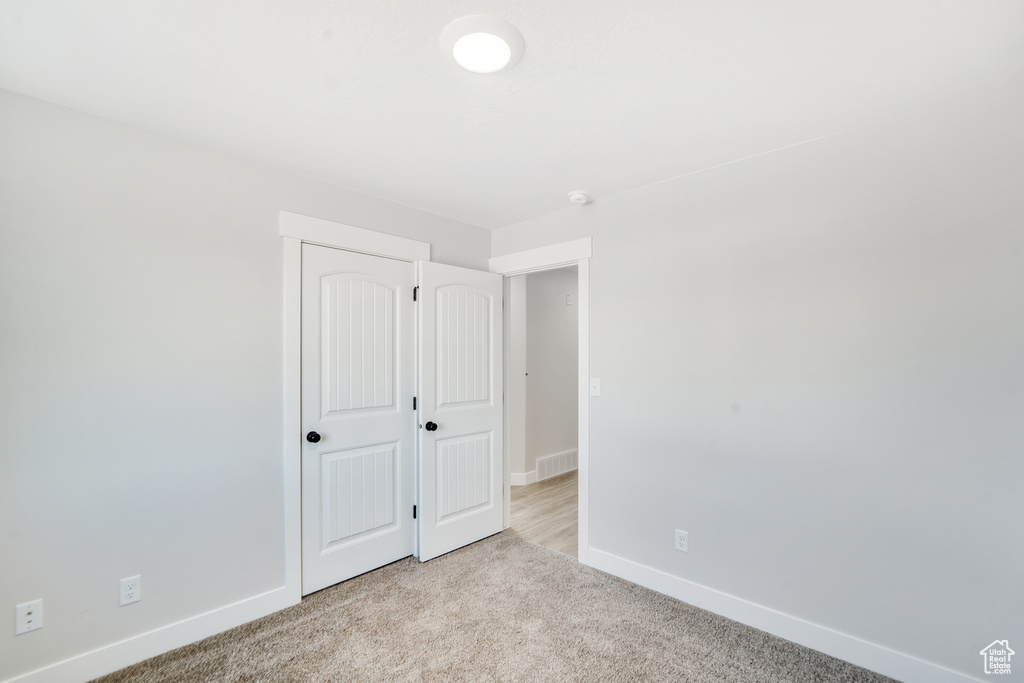 Unfurnished bedroom featuring baseboards, visible vents, and carpet