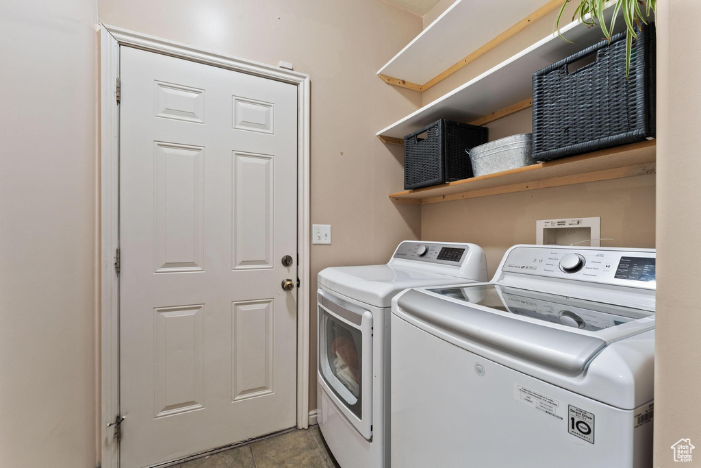 Laundry room featuring washer and clothes dryer and light tile patterned flooring