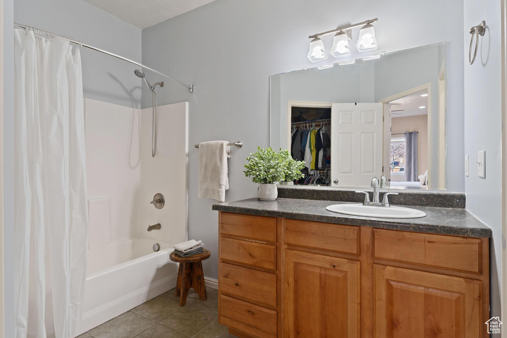 Bathroom featuring tile patterned flooring, vanity, and shower / tub combo