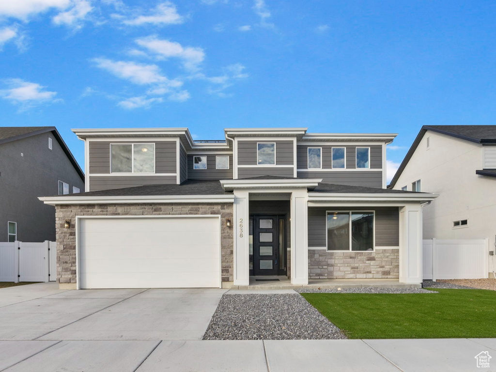 View of front of home with a front yard and a garage