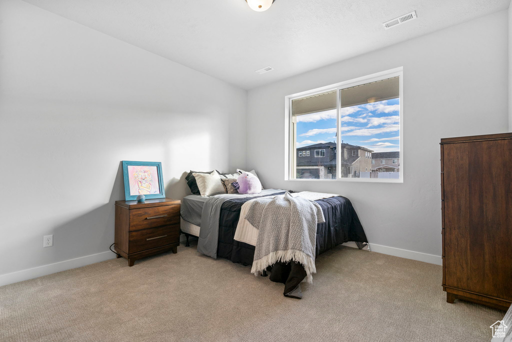 Bedroom featuring light colored carpet