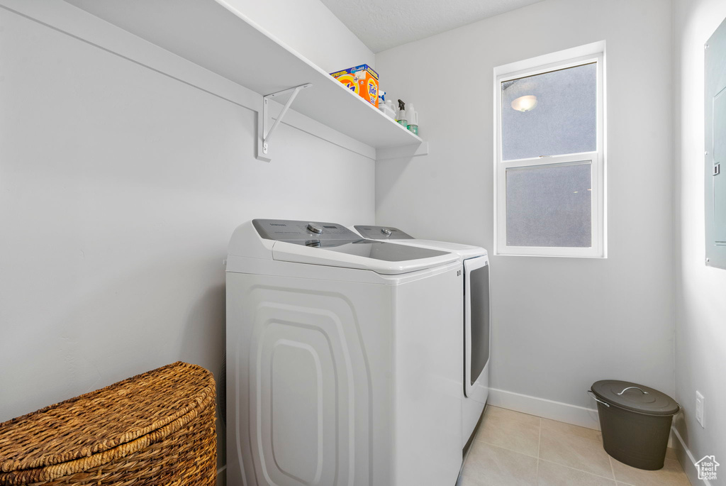 Laundry room featuring washer and clothes dryer and light tile patterned floors