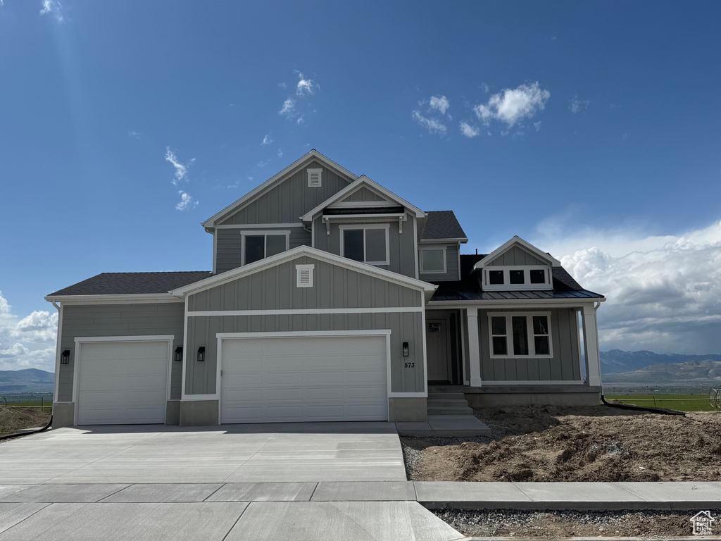 Craftsman house with covered porch, a standing seam roof, metal roof, concrete driveway, and an attached garage