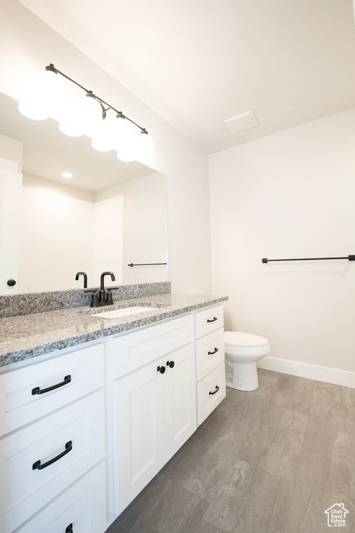 Bathroom with vanity, toilet, and baseboards