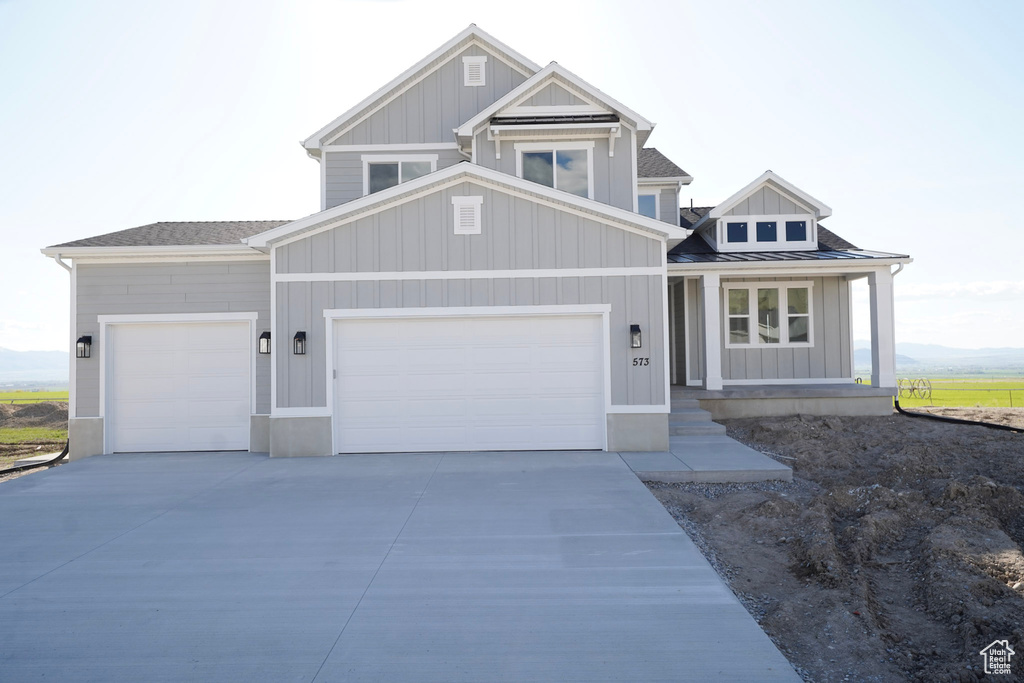 Craftsman-style home with a garage, board and batten siding, and concrete driveway