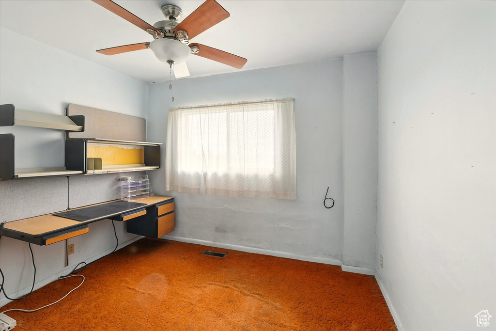 Unfurnished office with carpet floors, a ceiling fan, and baseboards