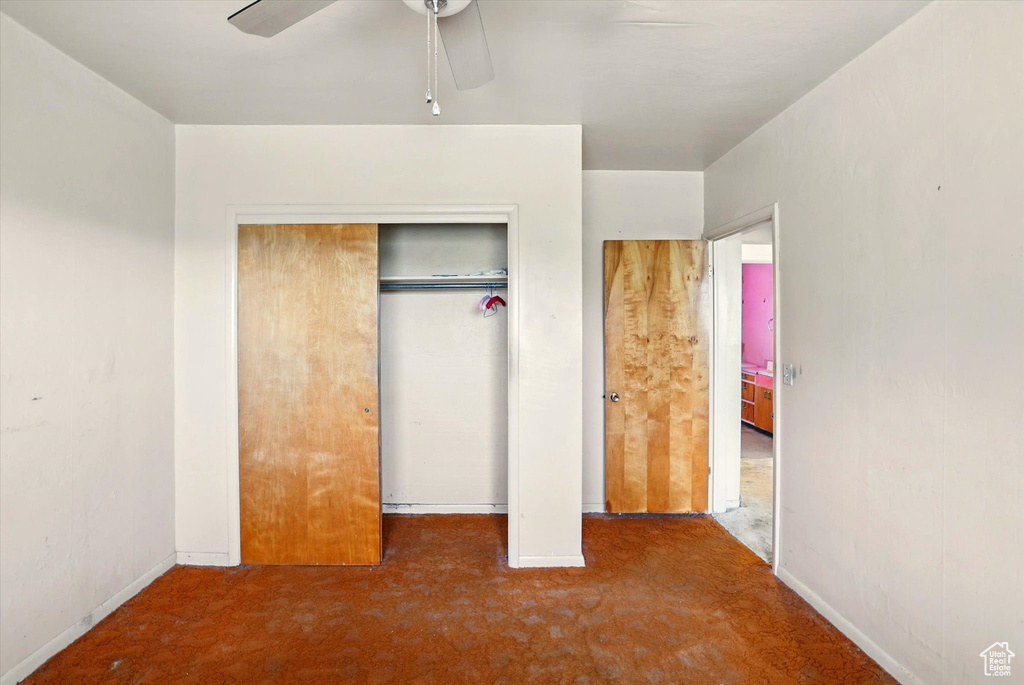 Unfurnished bedroom with carpet floors, baseboards, a closet, and ceiling fan