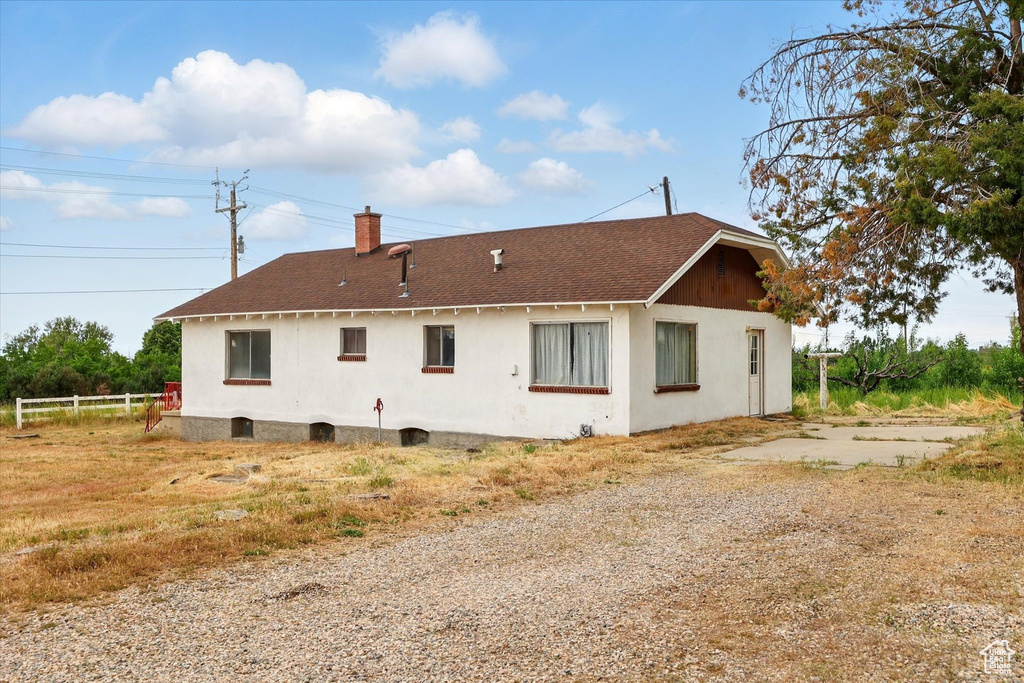 Rear view of property with a chimney and a shingled roof