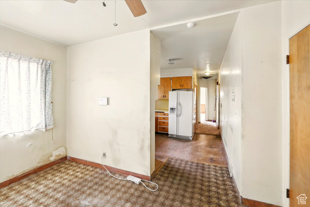 Interior space with ceiling fan, baseboards, and carpet floors