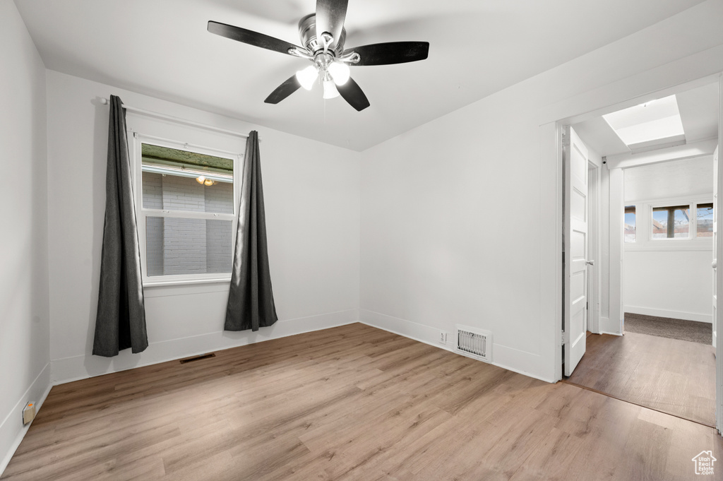 Empty room featuring ceiling fan and light hardwood / wood-style flooring