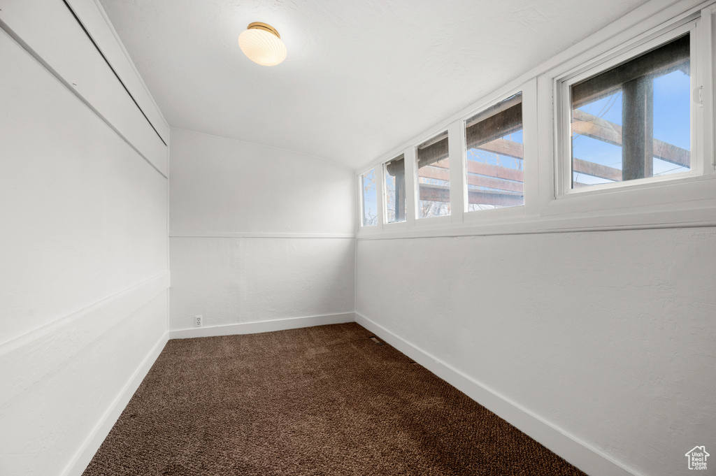 Spare room featuring dark colored carpet