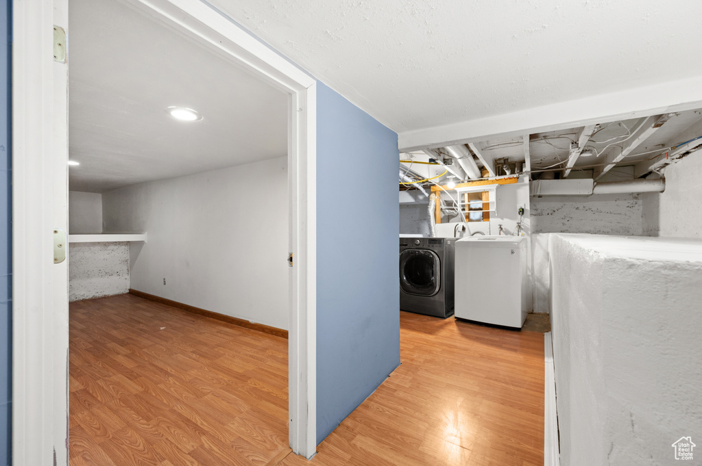 Laundry area featuring washer and clothes dryer and hardwood / wood-style flooring