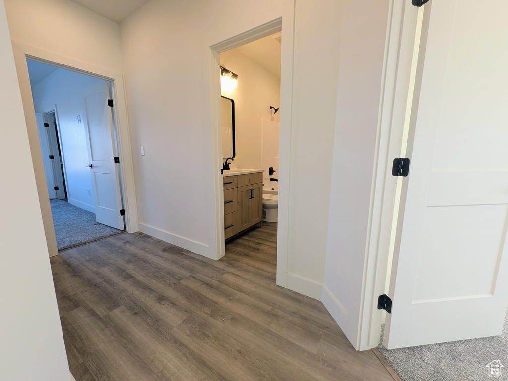 Hall with sink and dark wood-type flooring