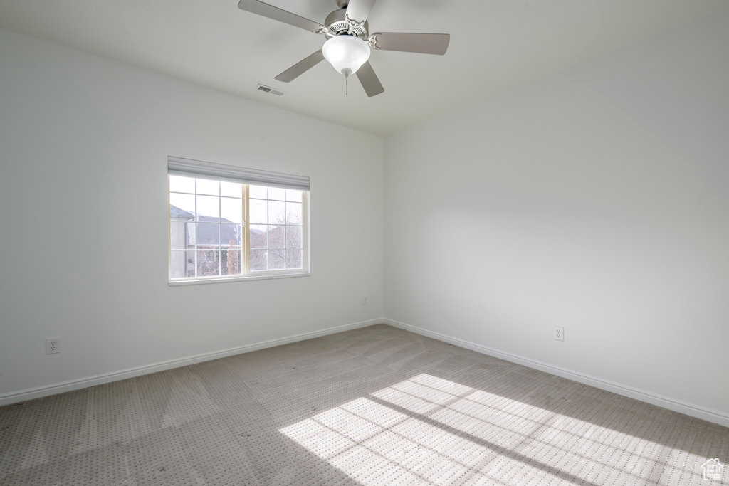 Carpeted spare room with ceiling fan