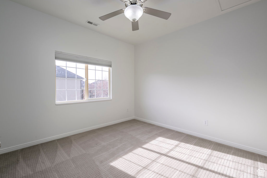 Carpeted empty room with ceiling fan