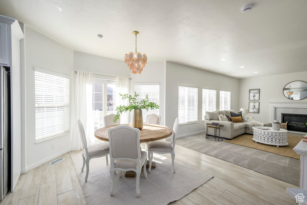 Dining room with an inviting chandelier and light hardwood / wood-style flooring