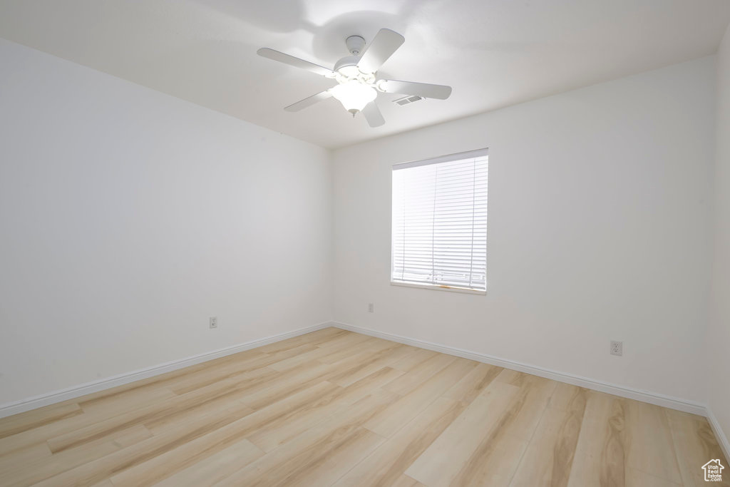 Empty room featuring ceiling fan and light wood-type flooring