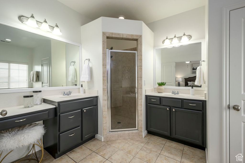 Bathroom with tile patterned floors, vanity, and walk in shower