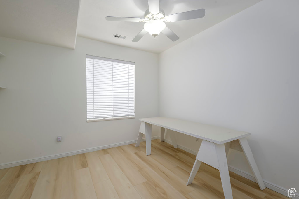 Unfurnished office with light hardwood / wood-style floors and ceiling fan