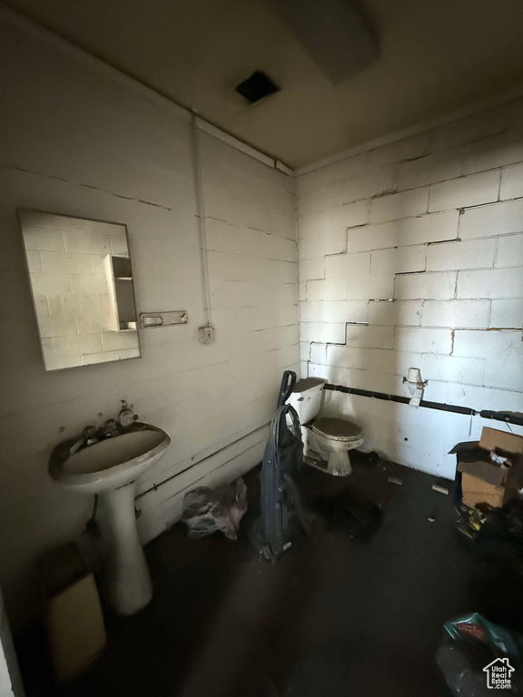 Bathroom featuring toilet and concrete floors