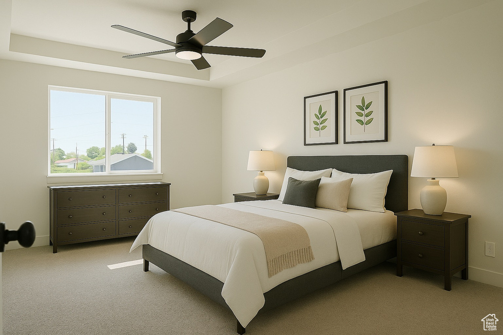 Bedroom featuring ceiling fan, a tray ceiling, and light colored carpet