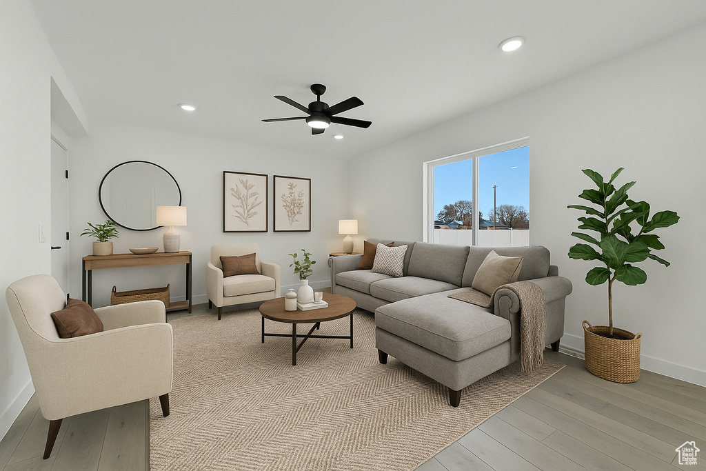 Living room featuring a ceiling fan, baseboards, recessed lighting, and light wood-style floors