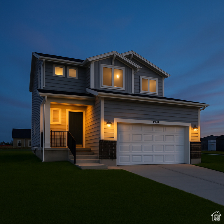 View of front of property featuring brick siding, an attached garage, driveway, and a front lawn