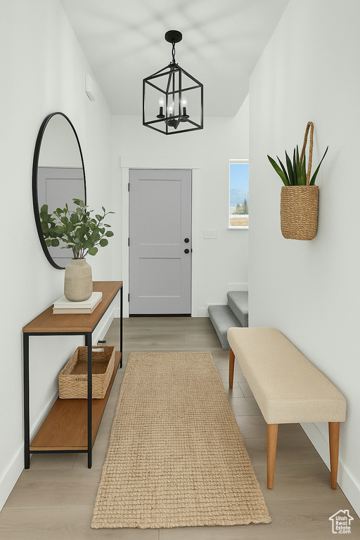 Entryway featuring light wood-type flooring, baseboards, and an inviting chandelier