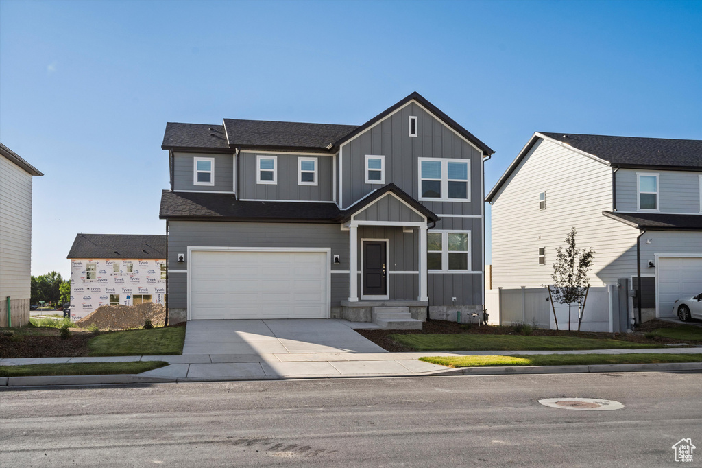 View of front of home featuring board and batten siding, concrete driveway, and an attached garage