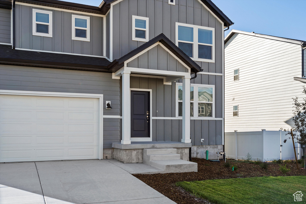 View of front facade with a garage, board and batten siding, and driveway