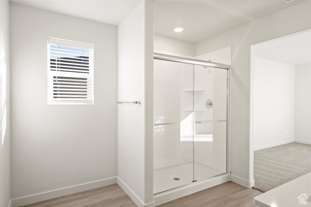 Bathroom featuring a shower stall, wood finished floors, and recessed lighting