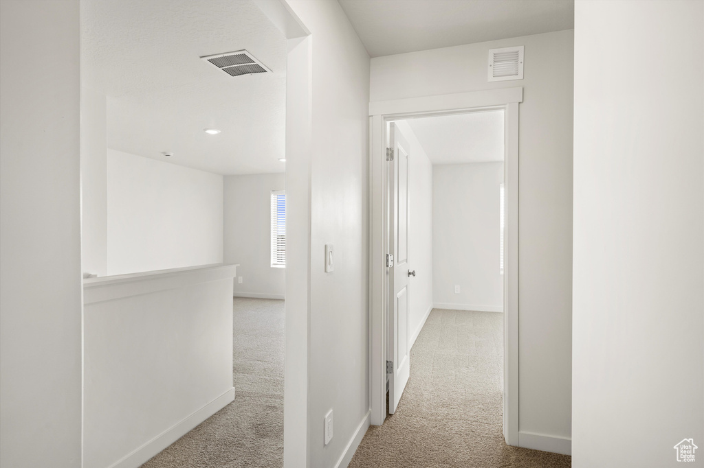 Hallway featuring carpet floors and baseboards