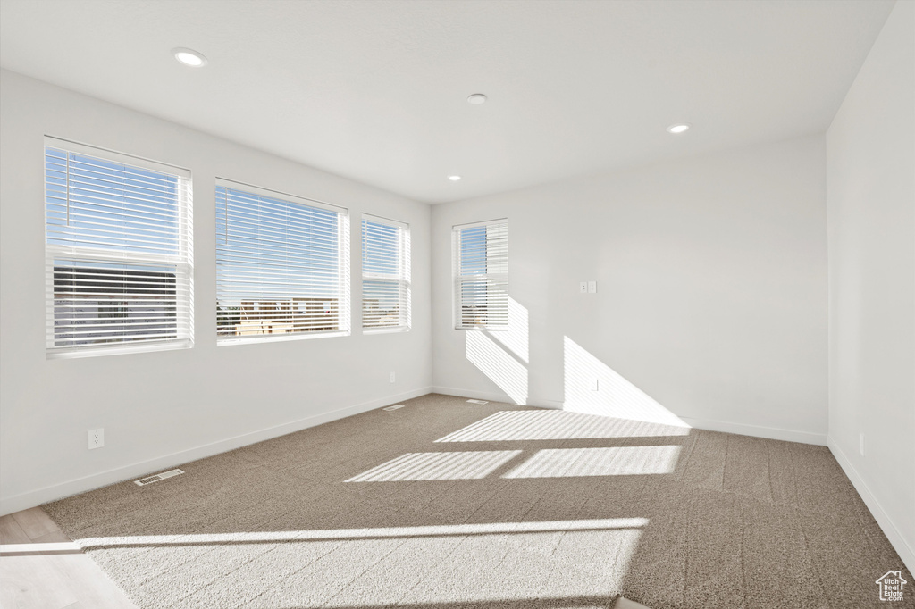 Carpeted empty room featuring recessed lighting