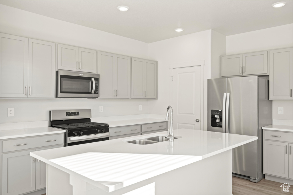 Kitchen featuring appliances with stainless steel finishes, light countertops, gray cabinets, and recessed lighting