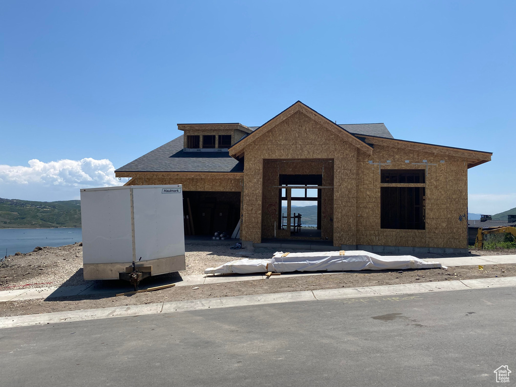 View of front of home with roof with shingles