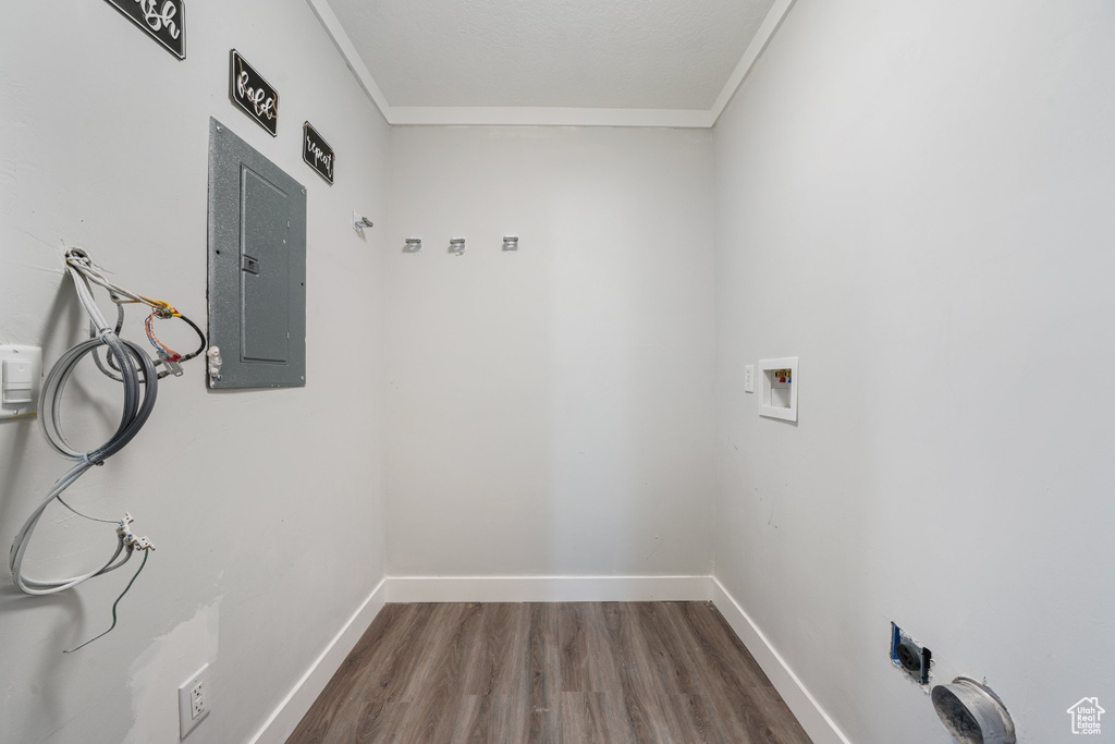 Laundry area featuring electric panel, ornamental molding, washer hookup, and wood-type flooring