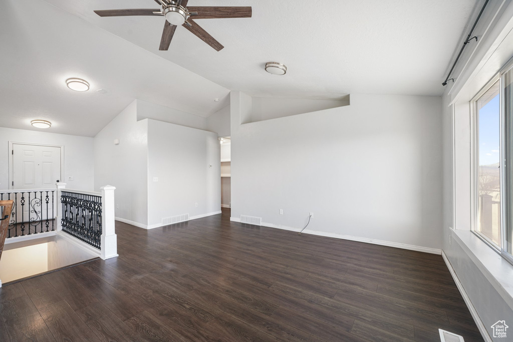 Interior space with lofted ceiling, ceiling fan, and dark hardwood / wood-style floors