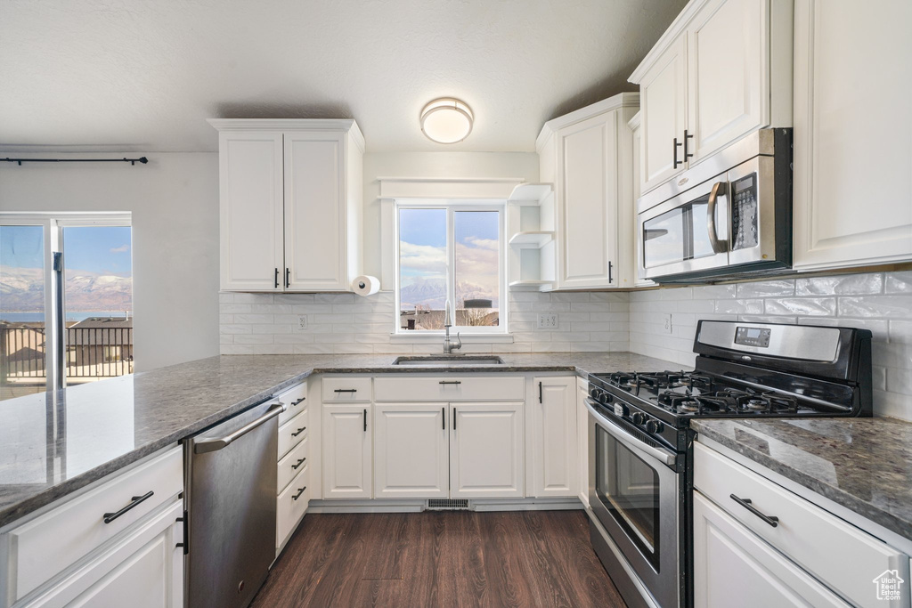Kitchen with sink, white cabinetry, and stainless steel appliances