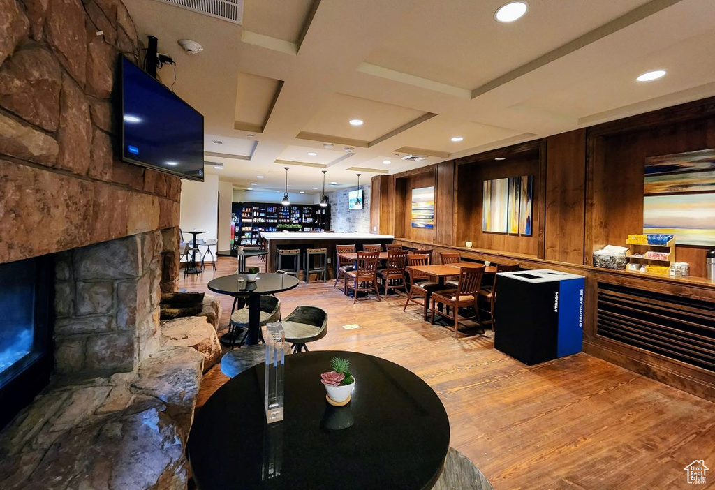 Interior space featuring beam ceiling, wooden walls, coffered ceiling, and light wood-type flooring