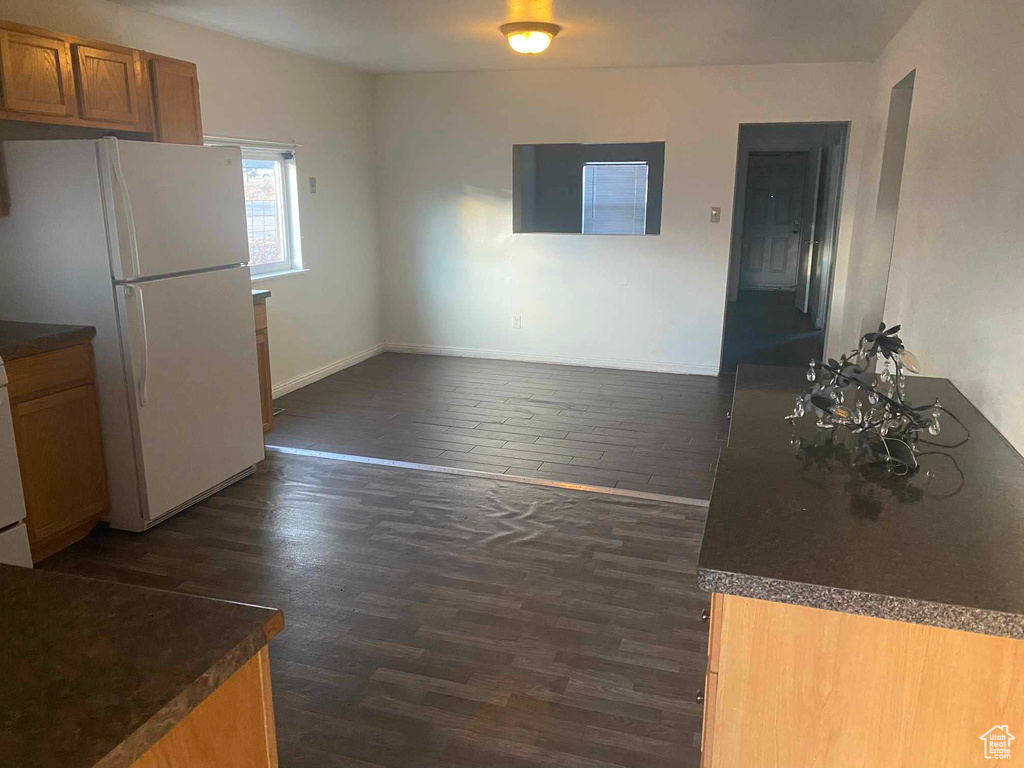 Kitchen featuring white fridge and dark wood-type flooring