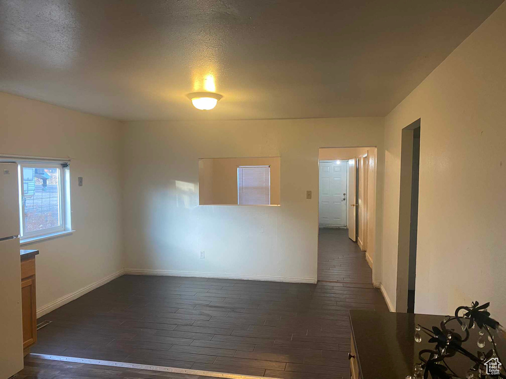 Unfurnished room with dark wood-type flooring and a textured ceiling