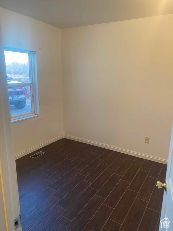 Spare room with dark hardwood / wood-style flooring