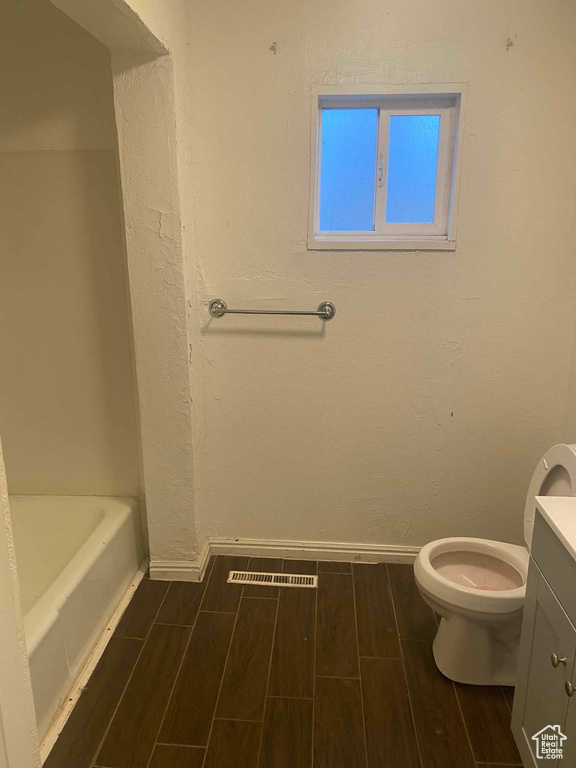 Bathroom with a washtub, toilet, and vanity