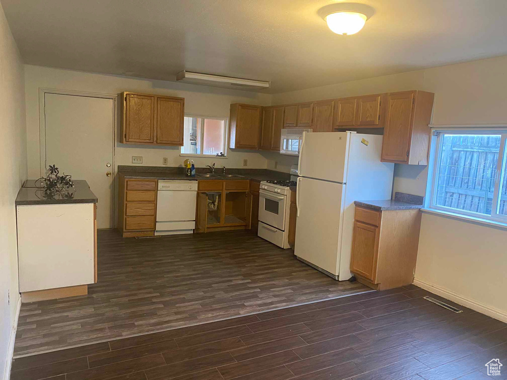 Kitchen featuring white appliances, dark hardwood / wood-style floors, and sink